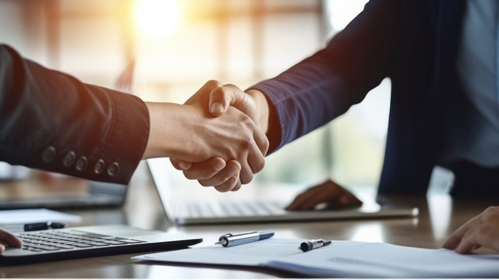 Zwei Personen geben sich die Hand zum Abschluss eines Arbeitsvertrags – ein symbolischer Moment für den Start in einen neuen Job oder eine neue Karrierestufe.