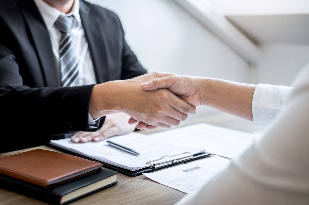 Erfolgreiches Vorstellungsgespräch, zwei Menschen schütteln sich die Hand